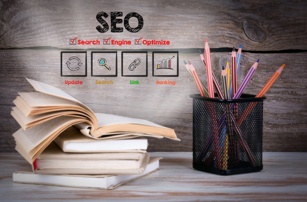 Livres sur le SEO superposés et crayons 