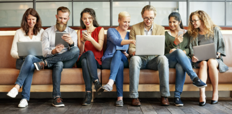 Groupe de citoyens utilisant ordinateurs portables, tablettes et smartphones dans un espace collaboratif, illustrant la participation citoyenne et l'engagement numérique.