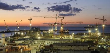 Port de Tanger Med au crépuscule, hub logistique international avec grues, infrastructures industrielles et activité maritime illustrant le dynamisme économique et l’export marocain