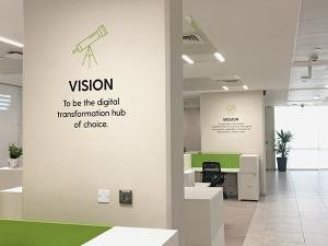 Espace de bureaux moderne avec mur affichant la vision et la mission d’une entreprise spécialisée en transformation digitale